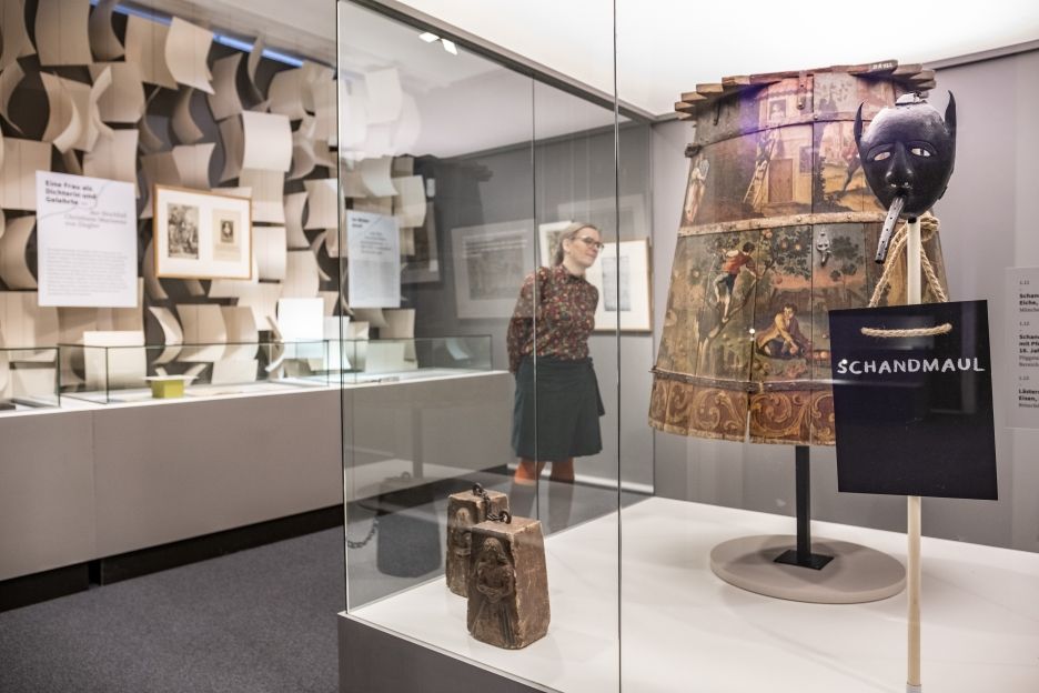 Eine Frau sieht sich ein Ausstellungsobjekt in der Ausstellung an.