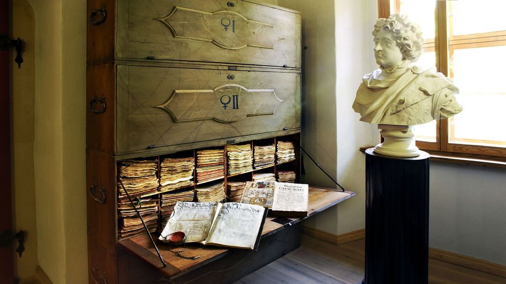 Es ist ein geöffneter, historischer Archivschrank zu sehen.